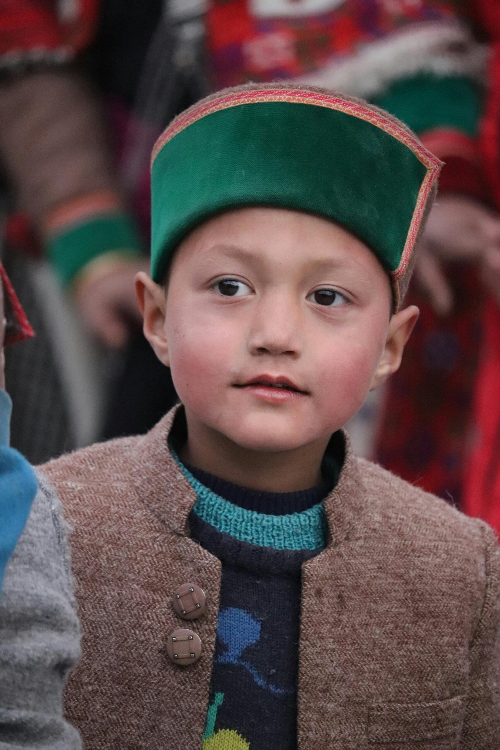 Charming portrait of a young boy wearing traditional Himachali clothing in Sangla, India, captured outdoors.
